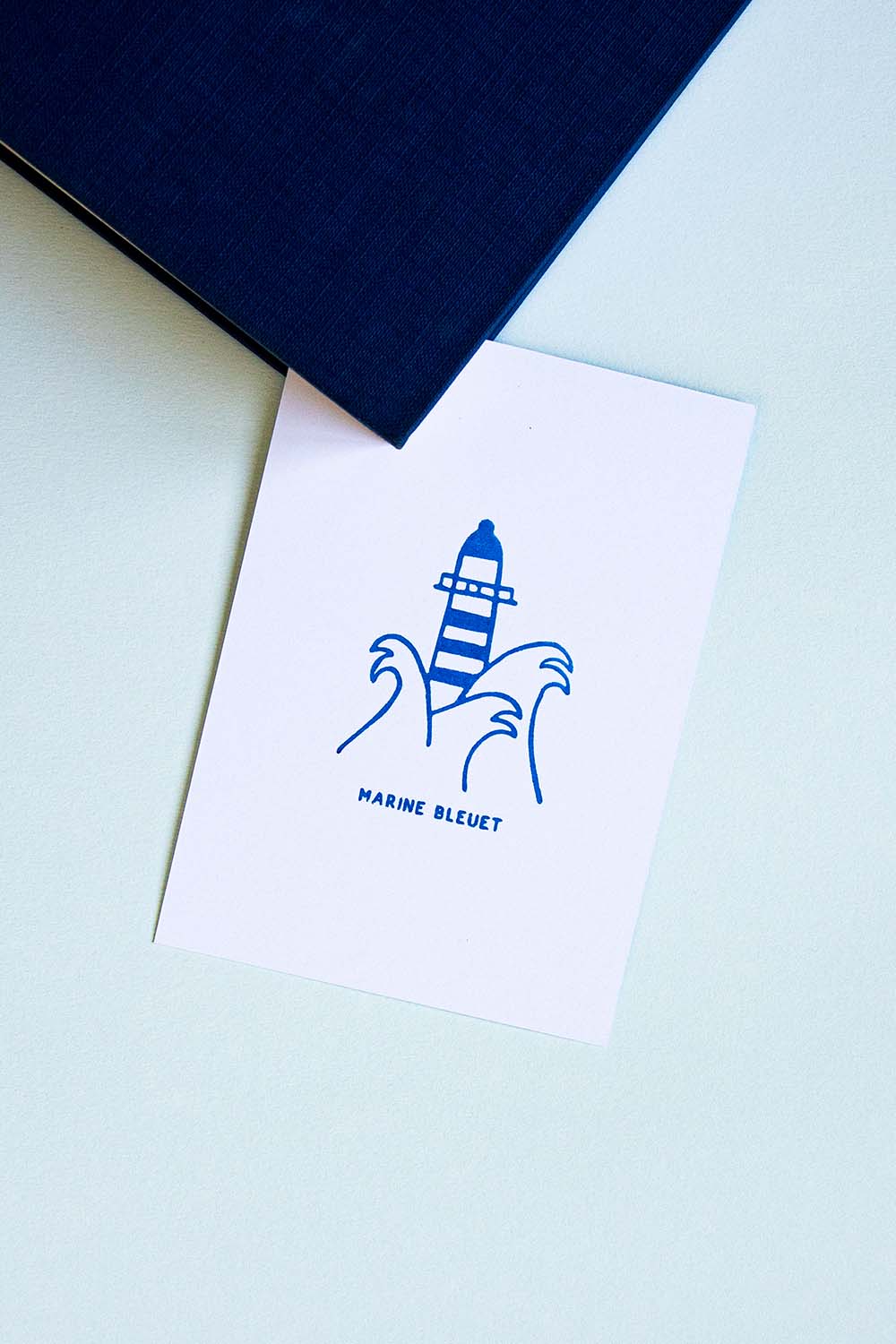 Portadilla de un libro estampada con un faro entre olas