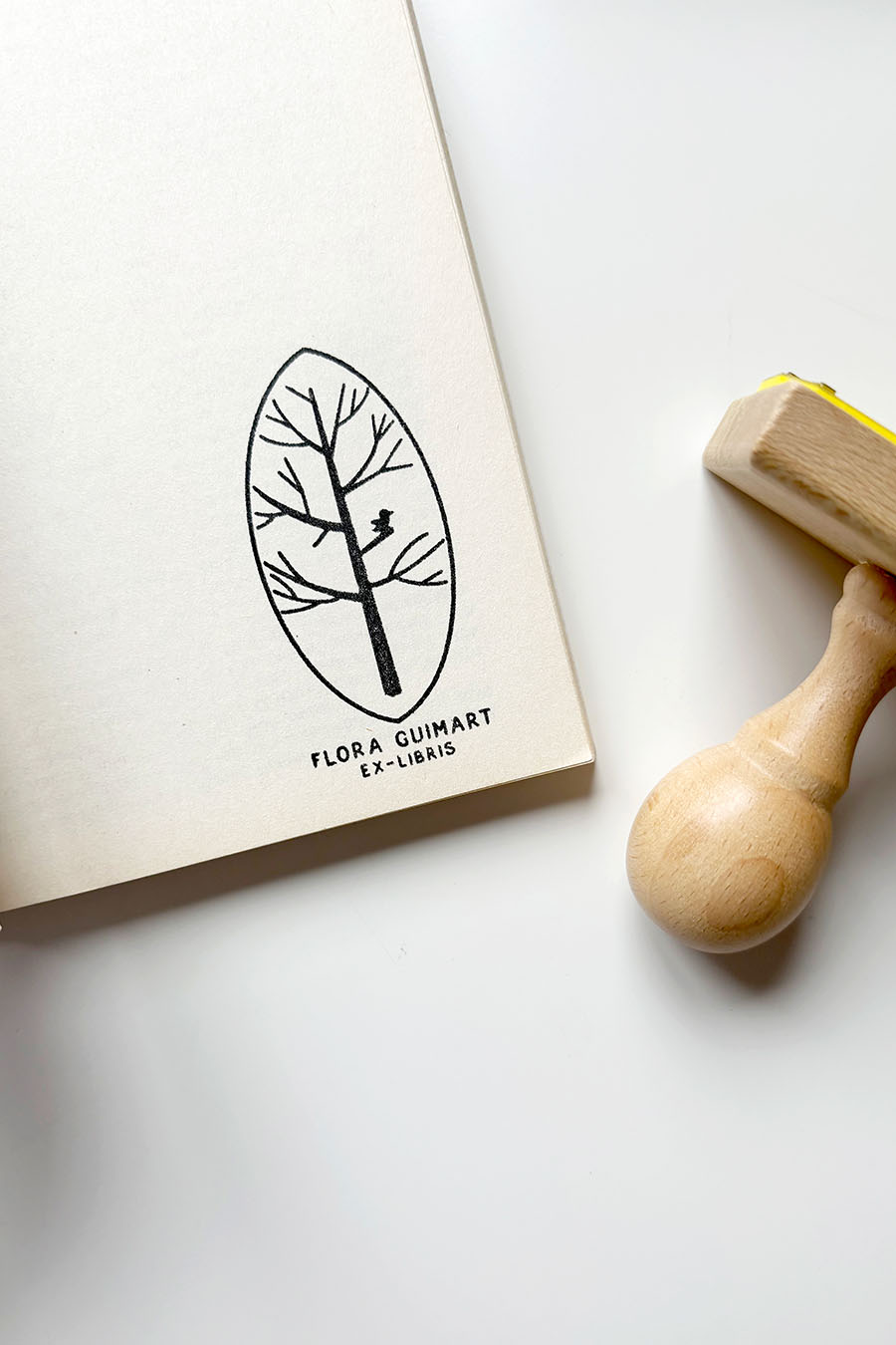 Portadilla de un libro estampada con un árbol sobre hoja y sello