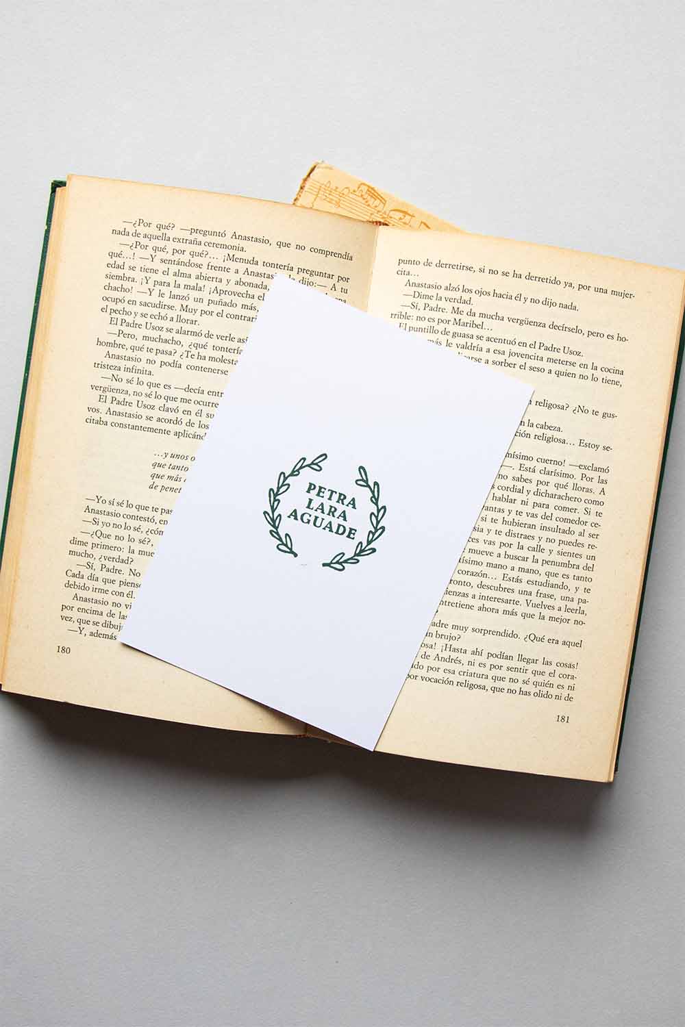 Portadilla de libro estampada con un sello exlibris de un círculo de hojas de laurel que enmarcan el nombe del propietario