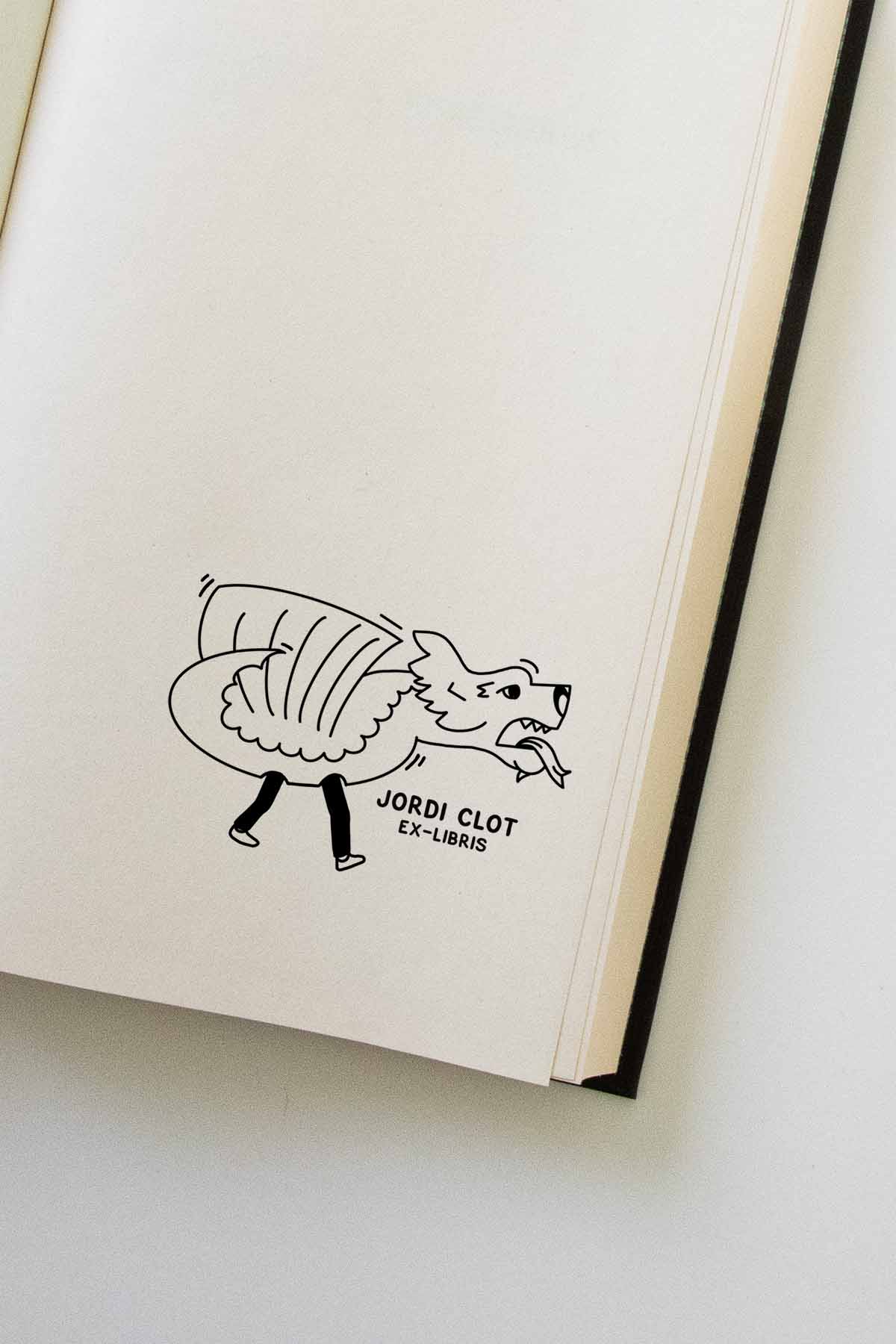 Una ilustración de un zorro caprichoso con un suéter a rayas en la página de un libro abierto; el dibujo incluye la etiqueta "Les Tampons de Roser Ex-libris Dragón personalizado.