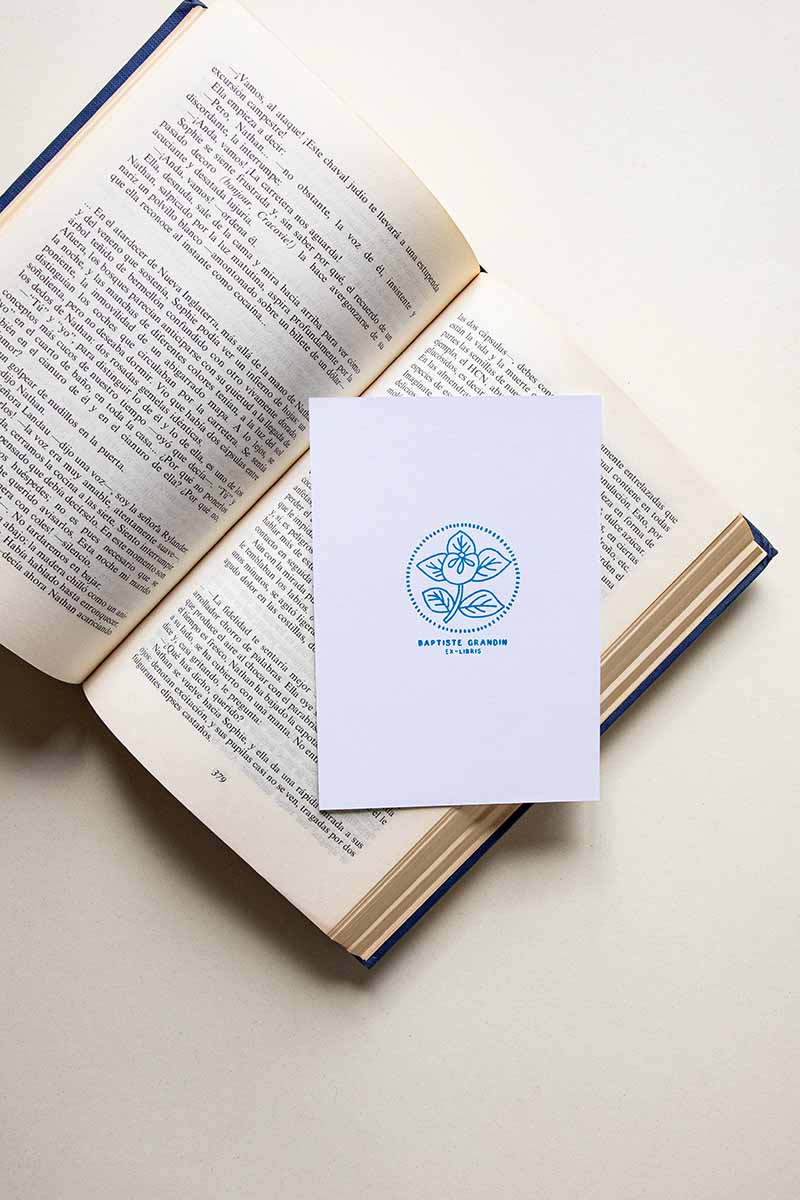 Portadilla de libro estampada con sello exlibris de una flor enmarcada en un círculo