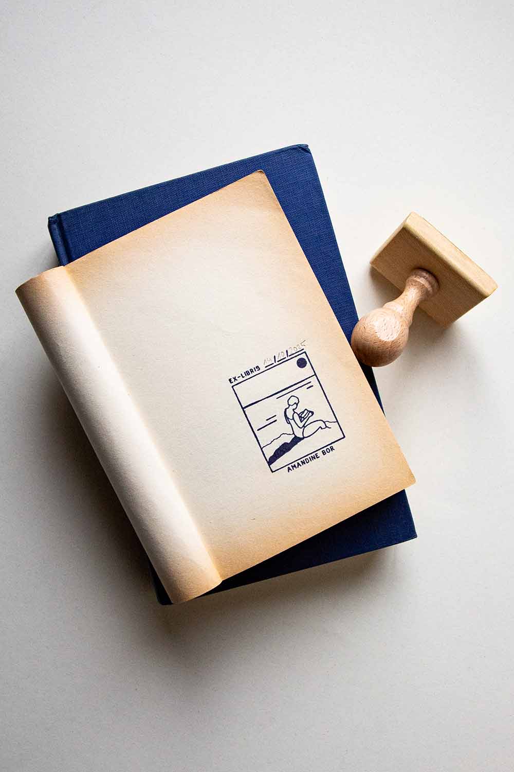 Portadilla de un libro estampada con una mujer leyendo junto al mar