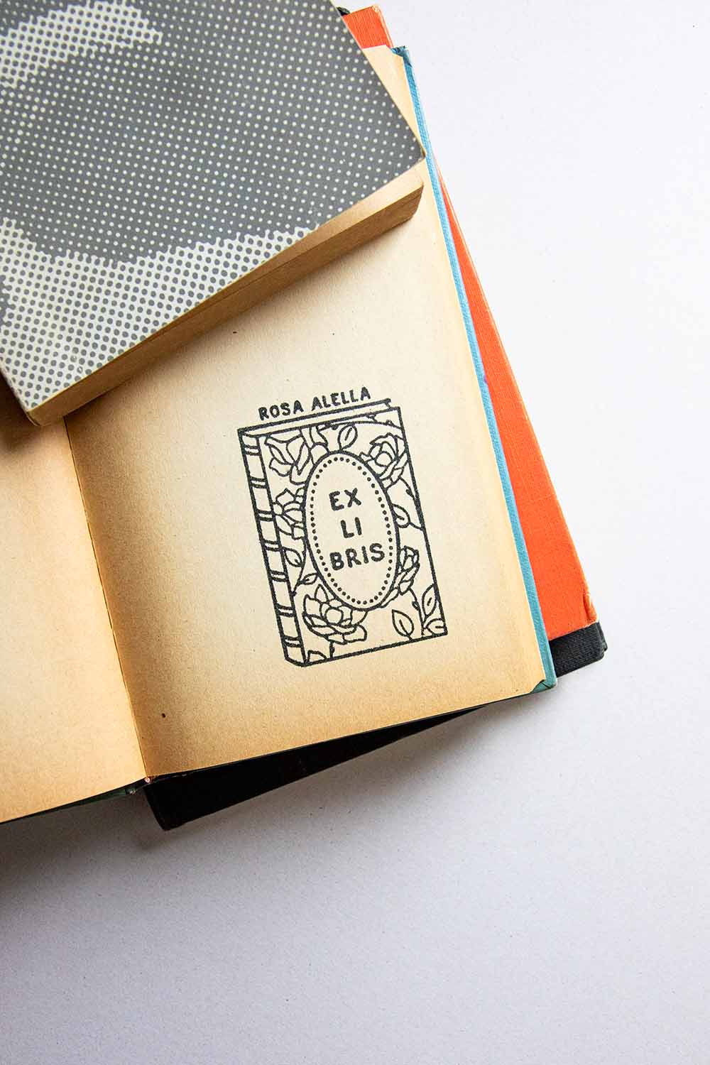 Portadilla de libro estampada con un libro con rosas en su portada