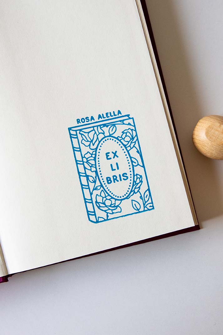 Portadilla de libro estampada con un libro con rosas en su portada