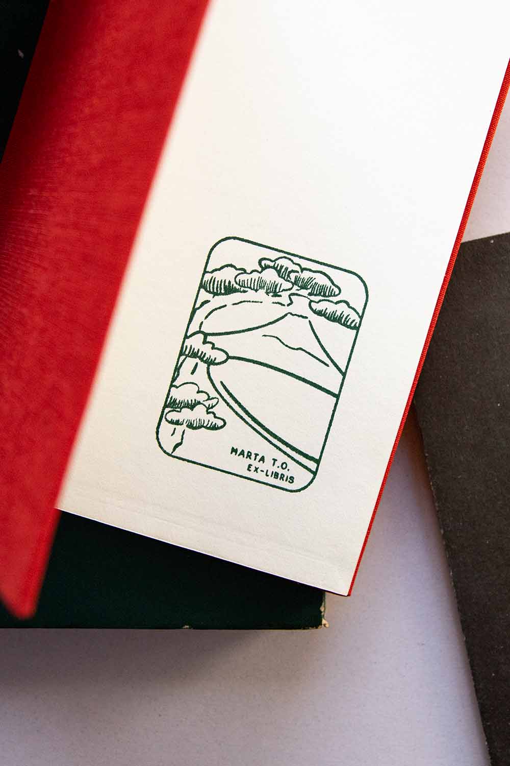Portadilla de libro estampada con sello exlibris del monte Fuji enmarcado por un árbol