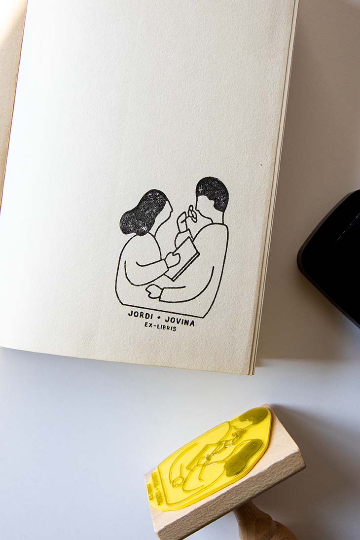 Portadilla de libro estampada con una pareja leyendo y oliendo una rosa