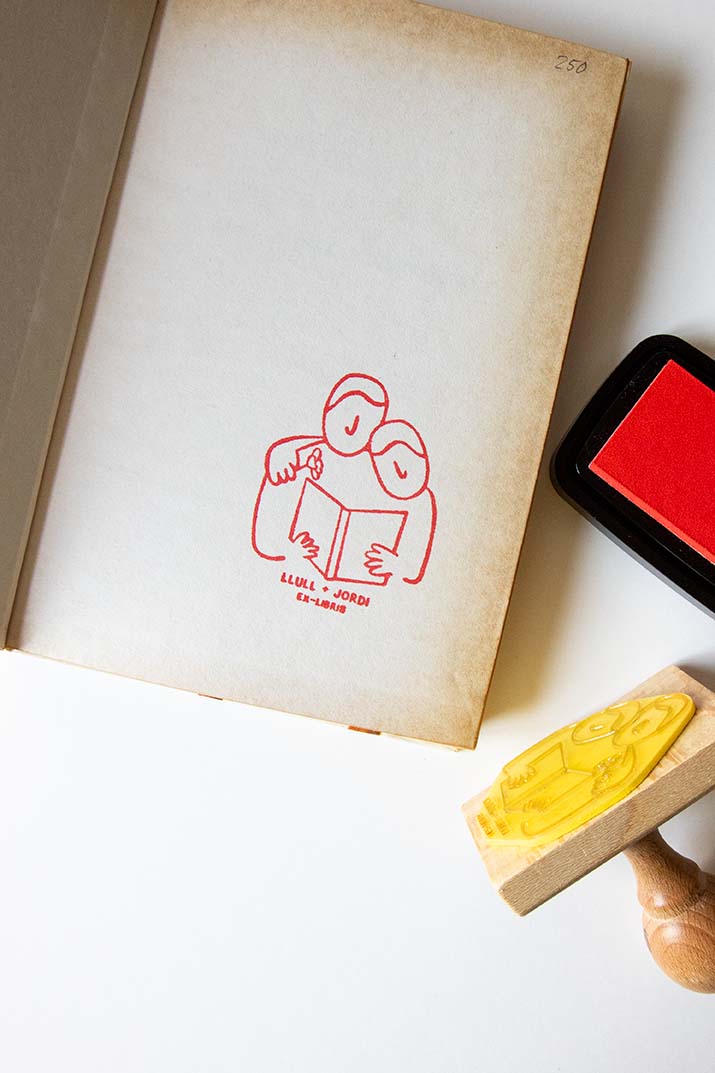 Portadilla de libro estampada con una pareja leyendo y sello