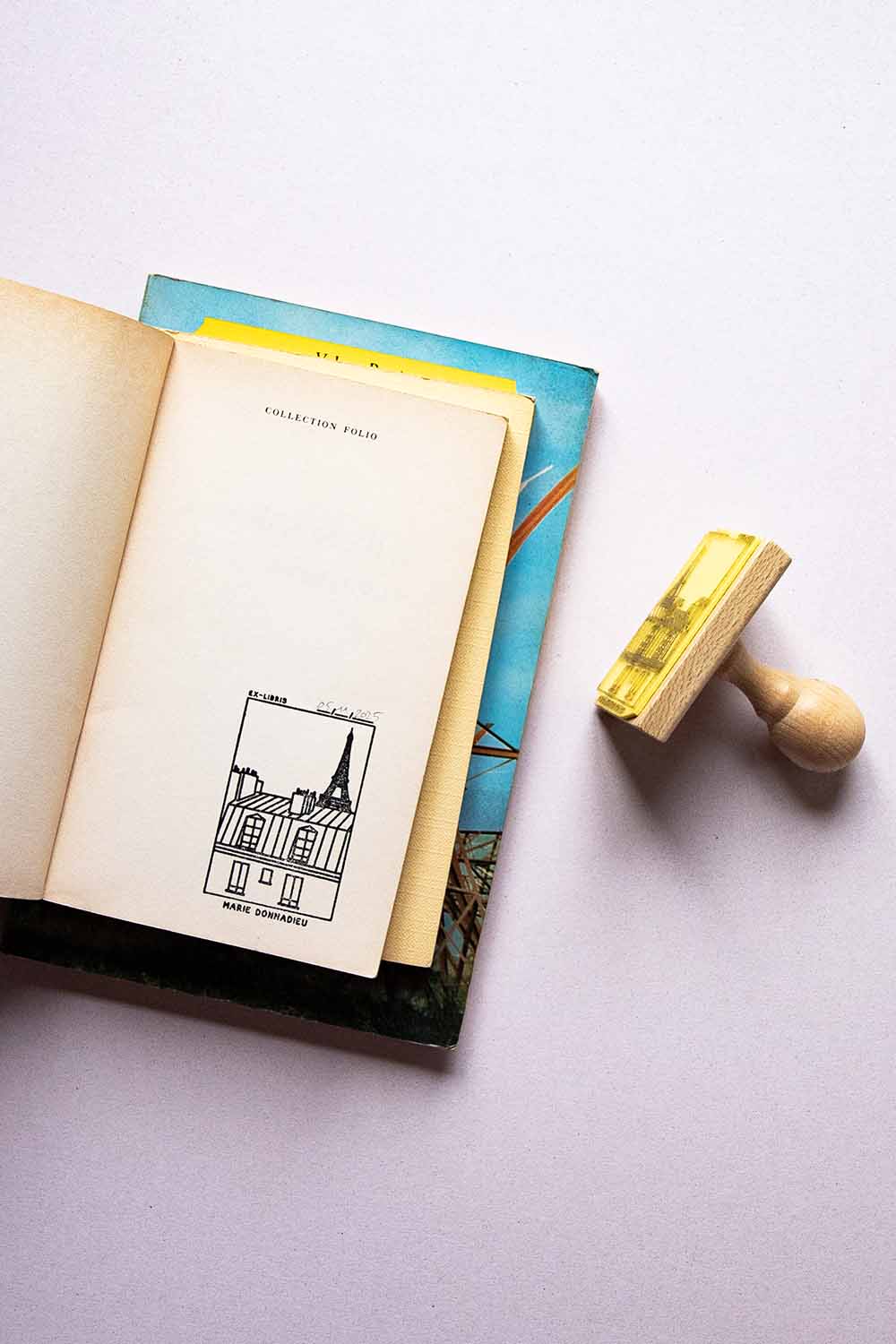 Portadilla de libro estampada con un edificio de París con la torre Eiffel y sello