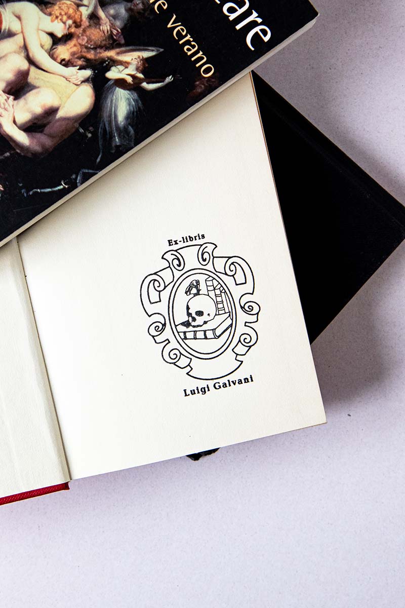 Portadilla de libro estampado con un escudo en el que se representa una vanitas con un craneo, libros y una mariposa