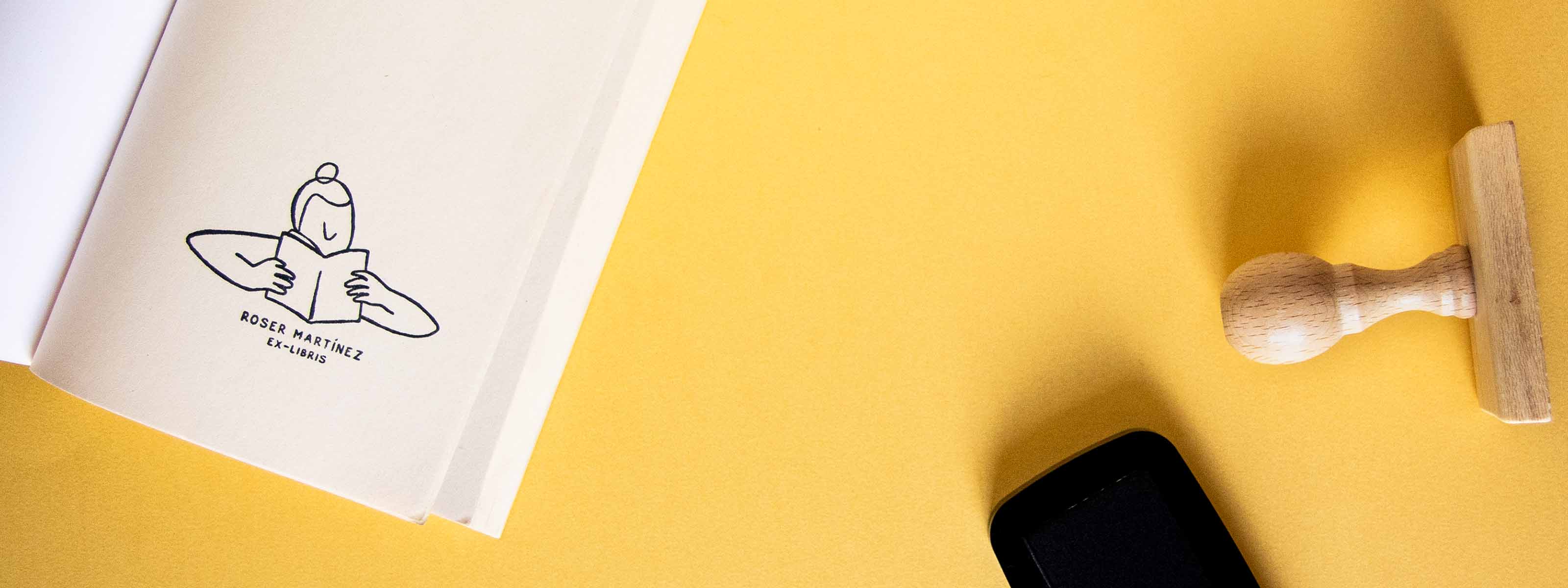 Exlibris personalitzat estampat a la pàgina de portada d'un llibre obert