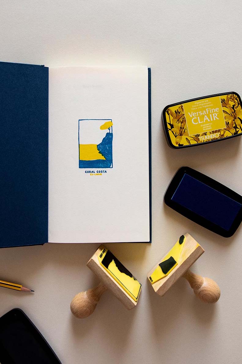 Portadilla de libro estampada con sello exlibris de una playa con un acantilado y sello