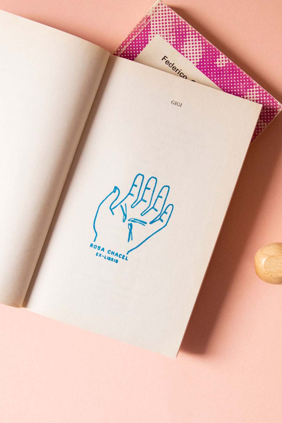 Portadilla de libro estampada con sello exlibris de una mano con semillas y sello