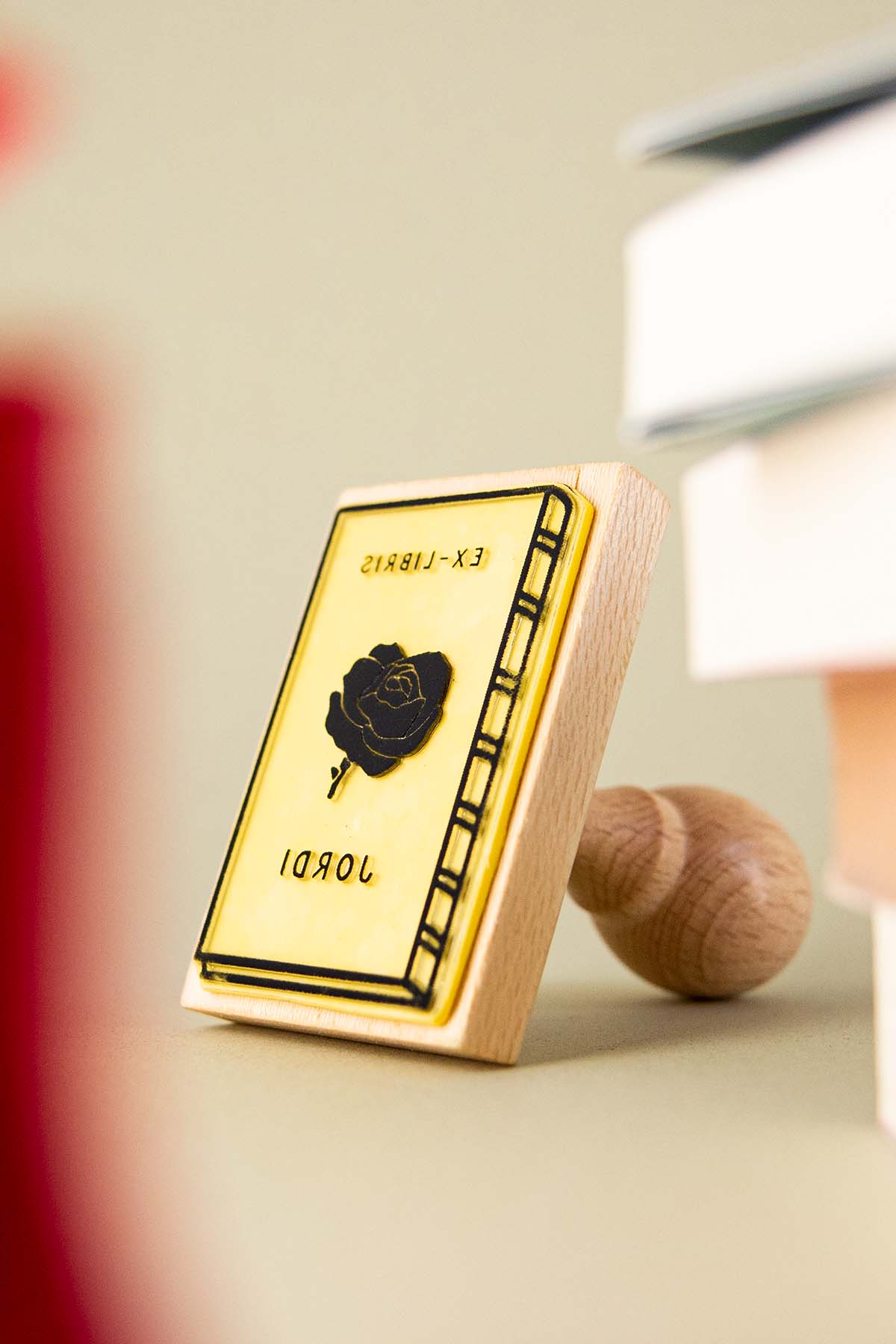 Sello exlibris grabado con un libro con una rosa enmedio