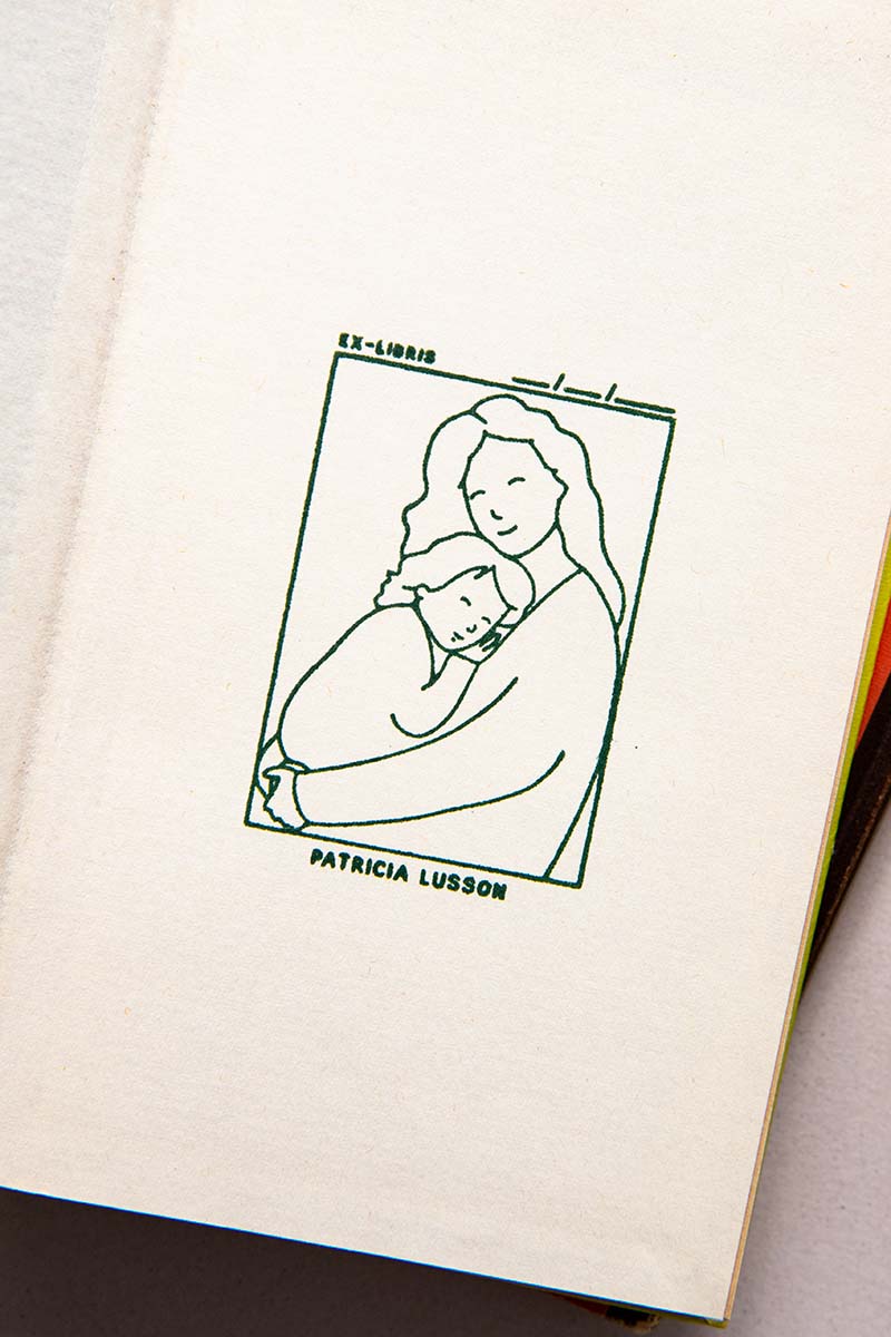Portadilla de libro estampado con sello exlibris con madre y hijo dándose un abrazo