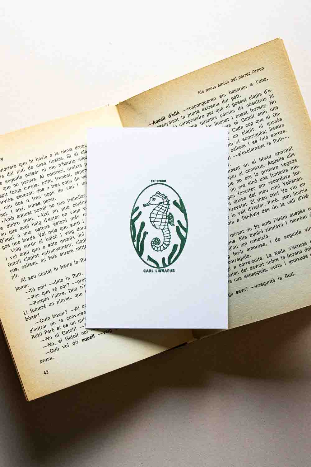Portadilla de libro estampado con sello exlibris con un caballito de mar