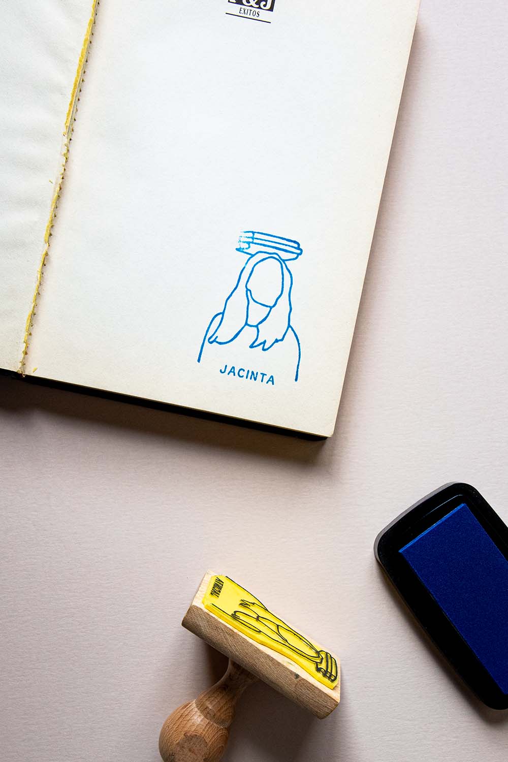 Portadilla de libro estampada con sello exlibris de una persona con libros encima de su cabeza y sello