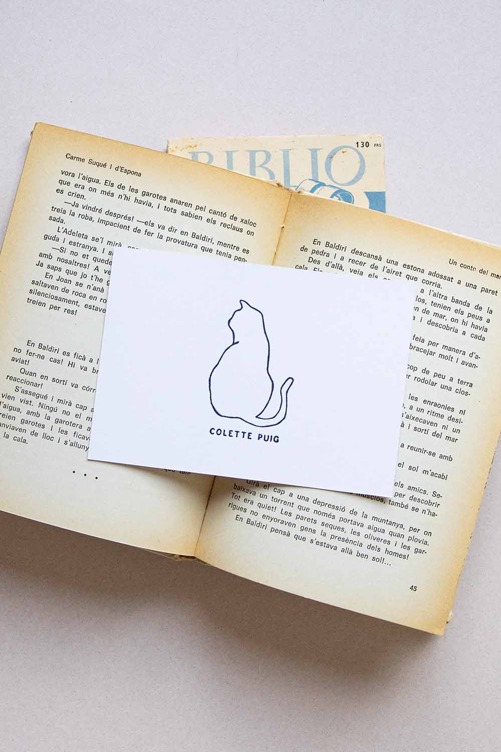 Portadilla de libro estampada con sello exlibris de un gato sentado de espaldas