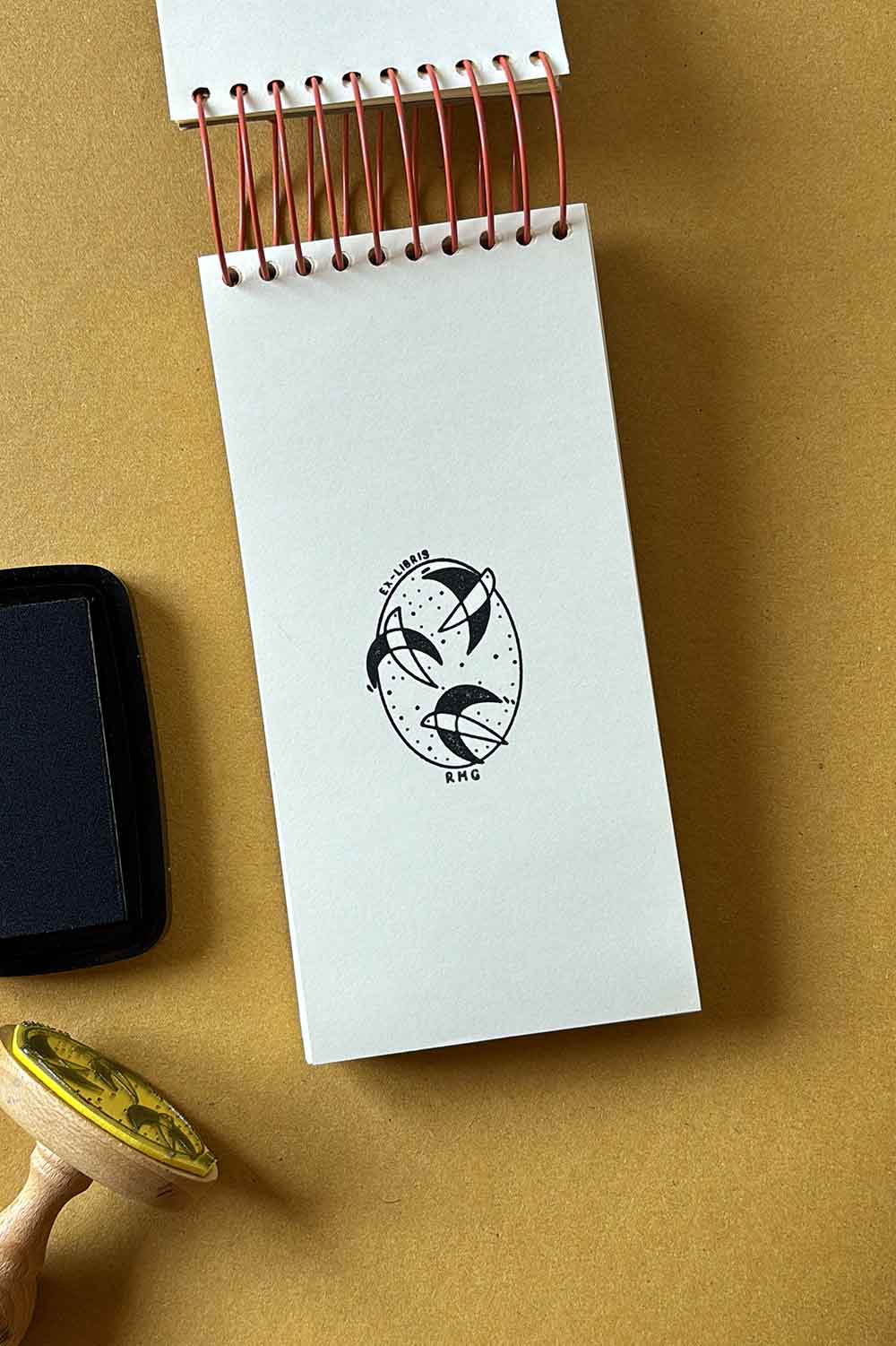 Portadilla de libro estampado con sello exlibris de tres golondrinas volando y sello