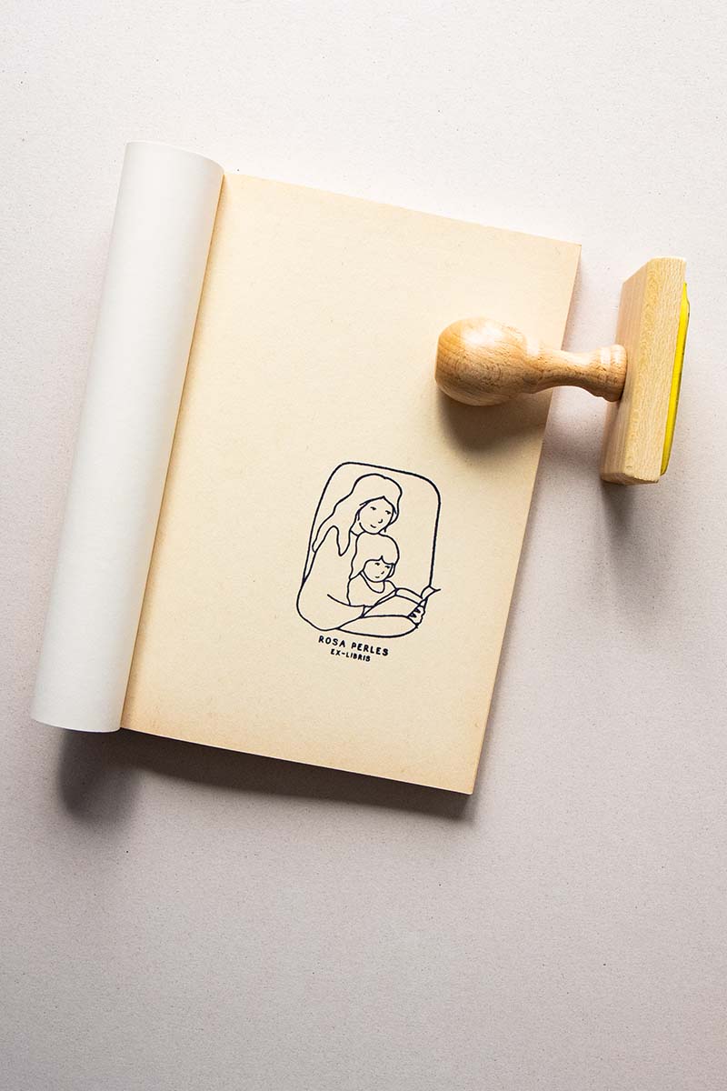 Portadilla de libro estampado con sello exlibris con madre y hija leyendo un mismo libro
