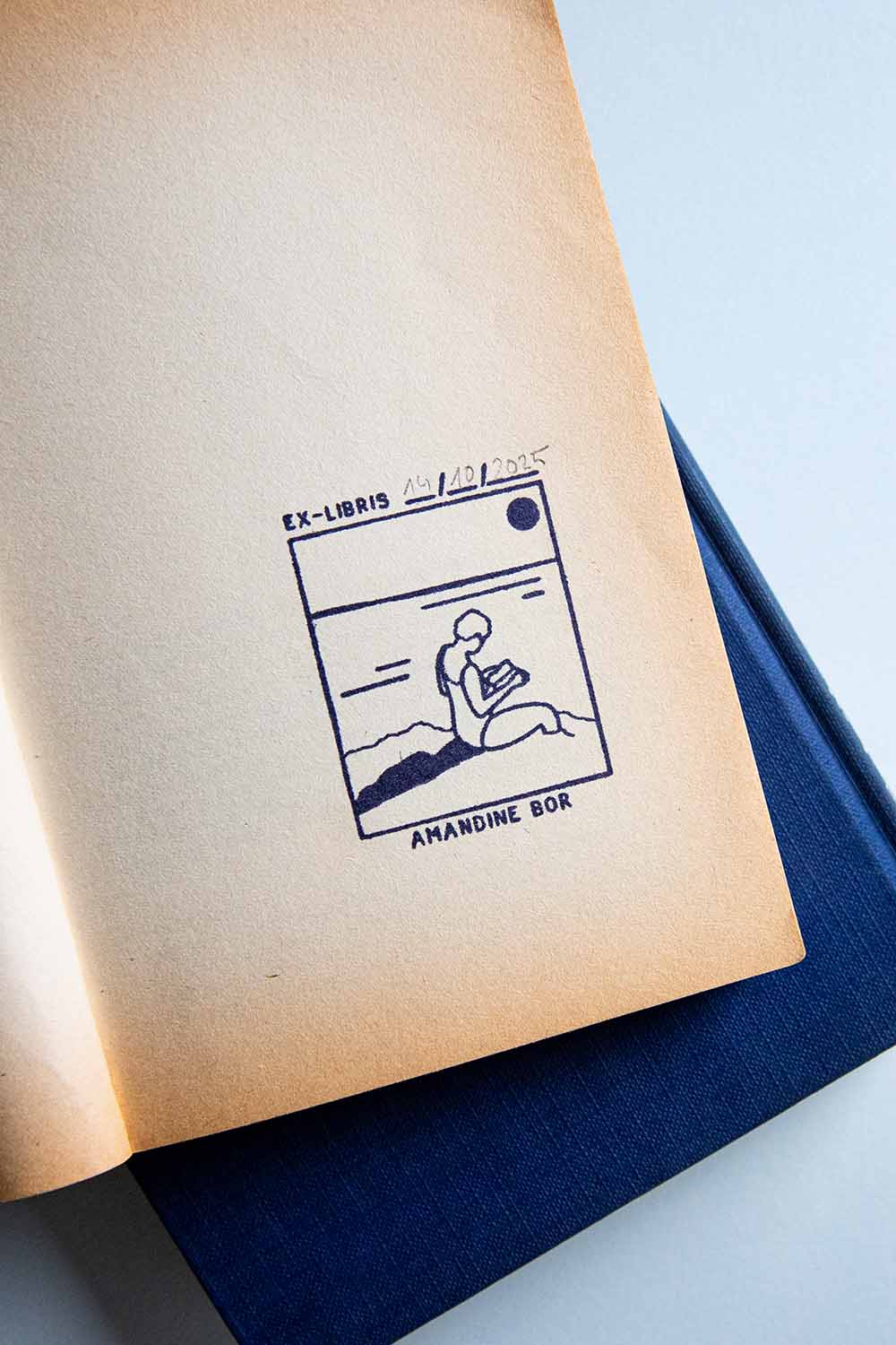 Portadilla de un libro estampada con una mujer leyendo junto al mar