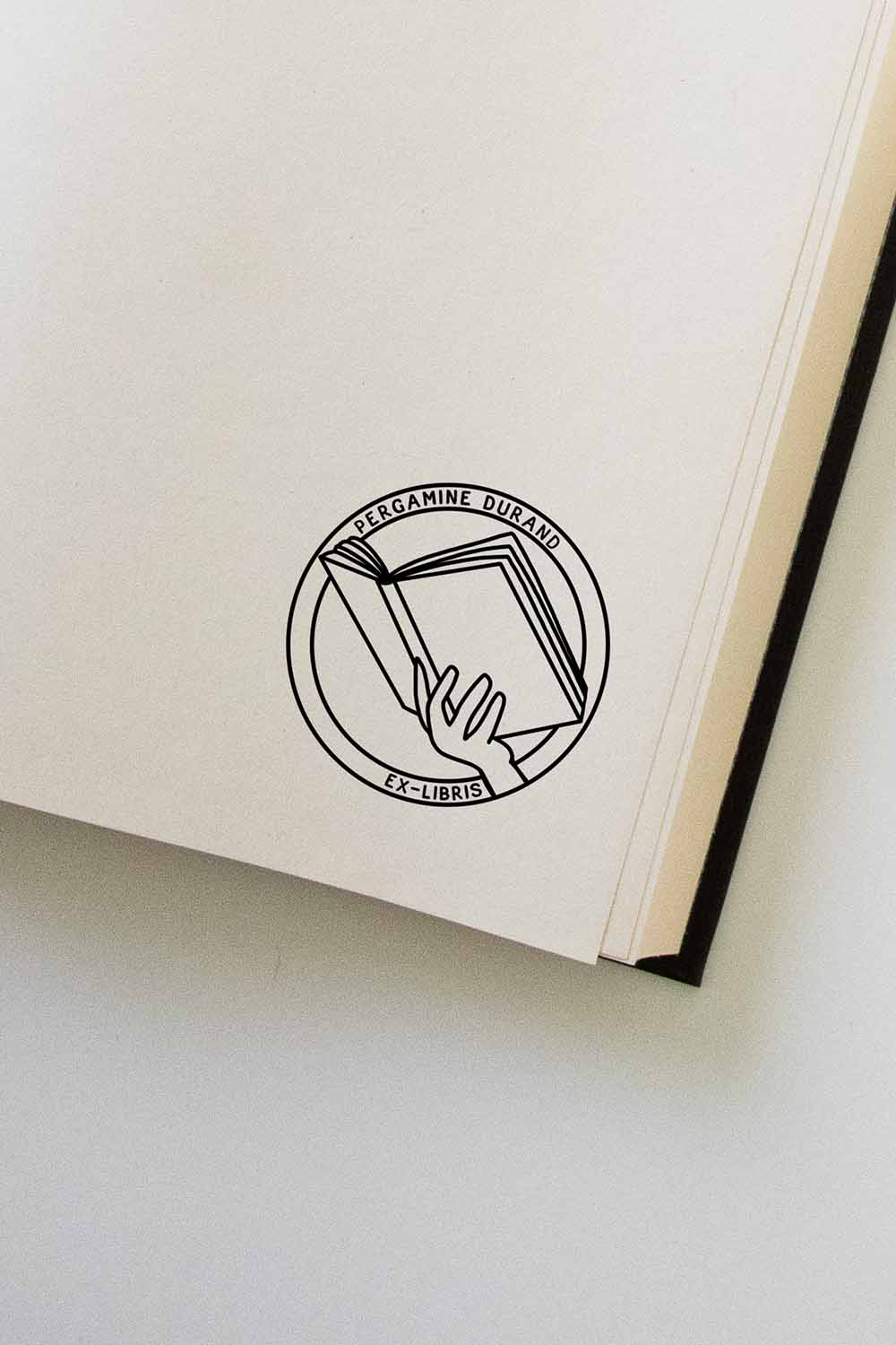 Portadilla de libro estampada con una mano sosteniendo un libro