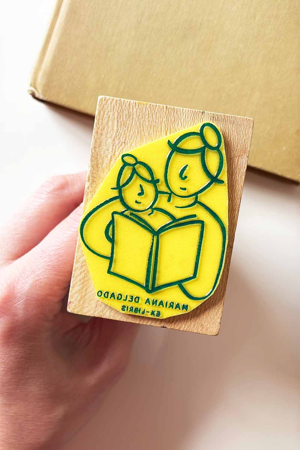 Sello exlibris grabado con una madre leyendo a su hija pequeña