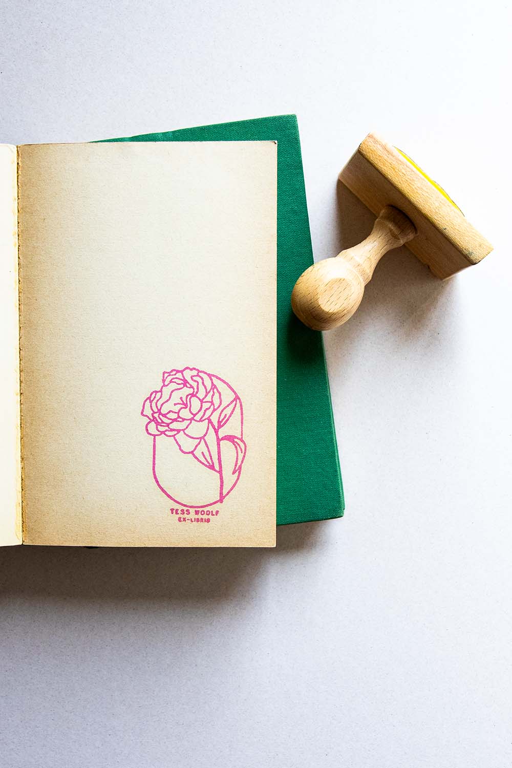 Portadilla de libro estampada con sello exlibris de una flor peonía y sello