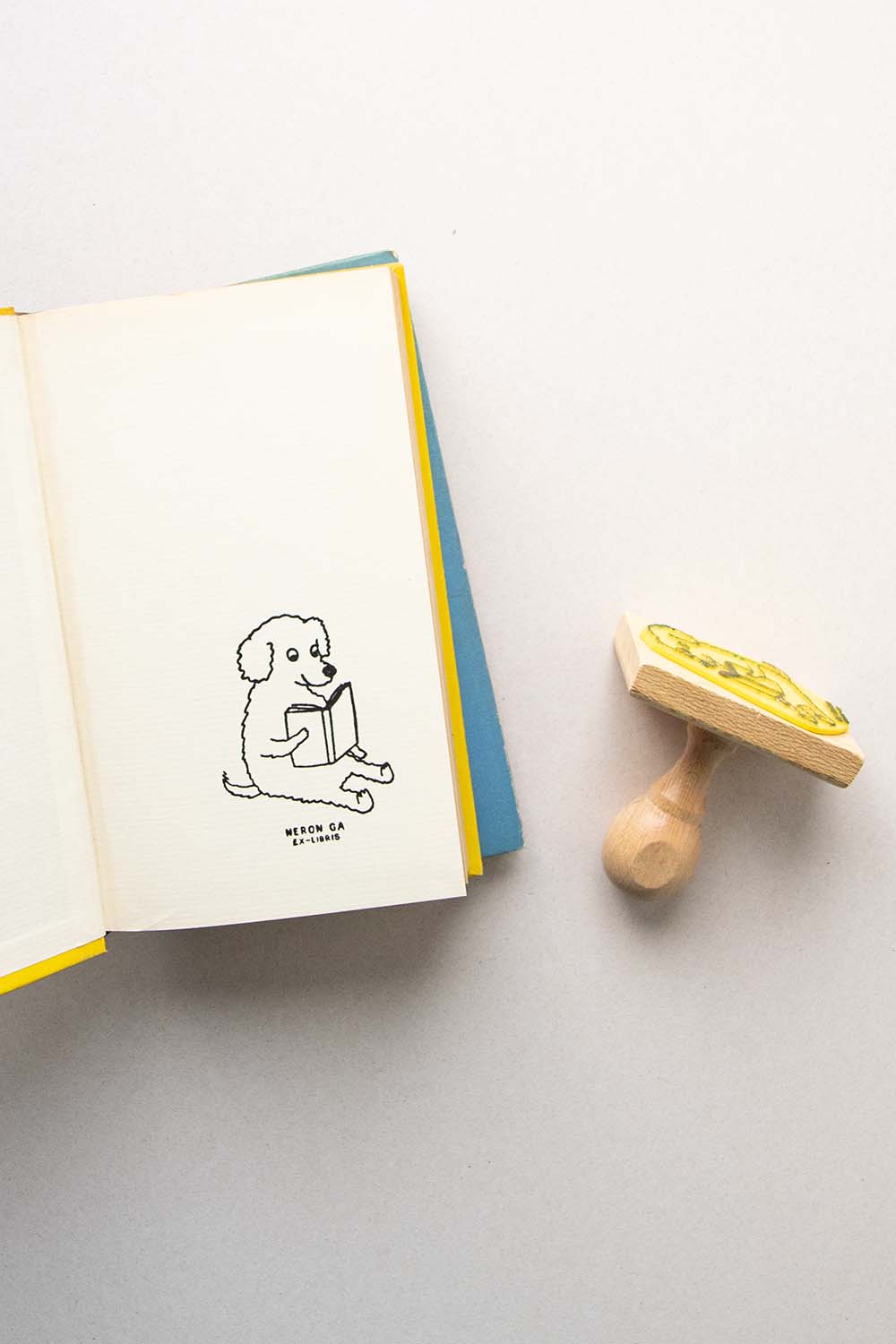 Portadilla de libro estampado con sello exlibris de un perro lector y sello