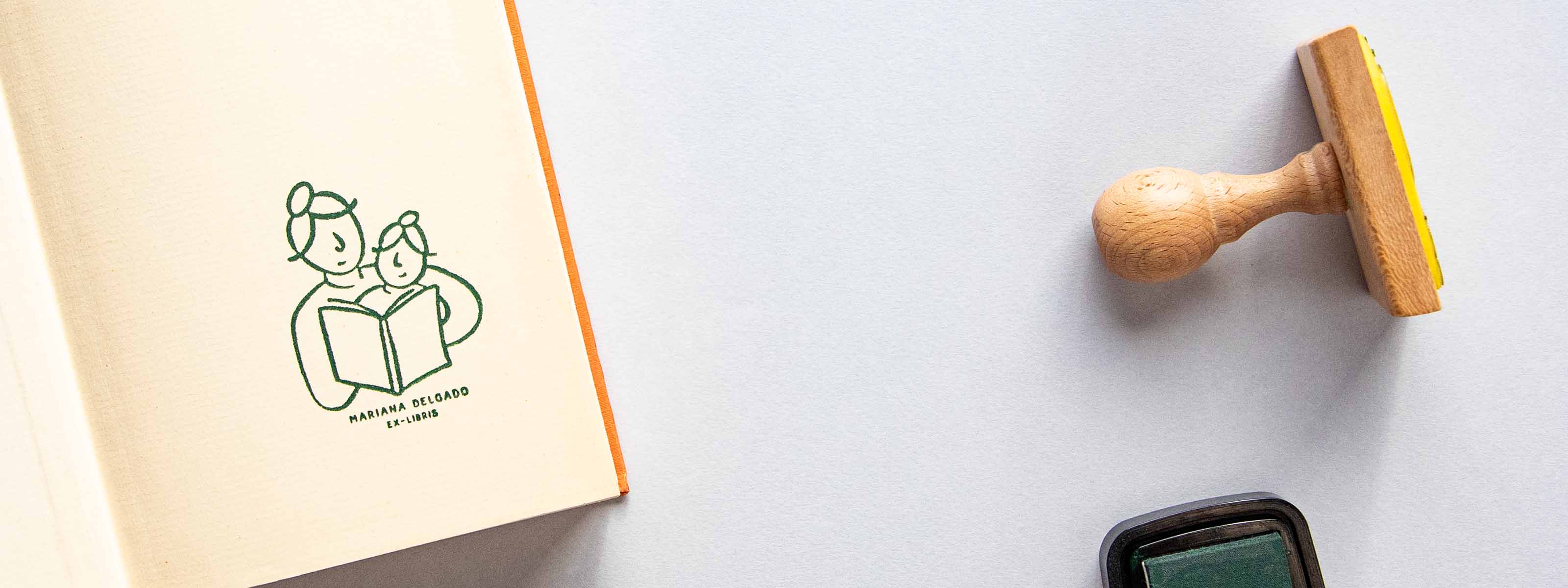 Exlibris personalizado sellado en la página de portada de un libro abierto con una madre y una hija compartiendo un momento de lectura