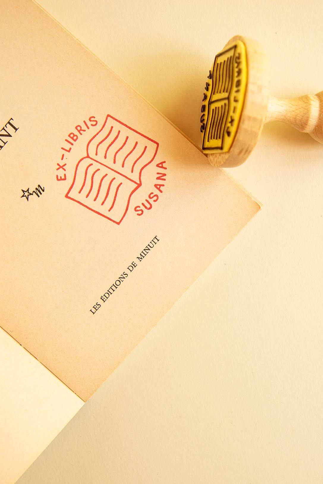 Portadilla de libro estampada con sello exlibris de un libro abierto
