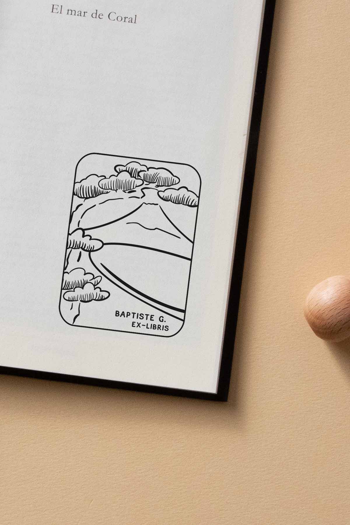Portadilla de libro estampada con sello exlibris del monte Fuji enmarcado por un árbol