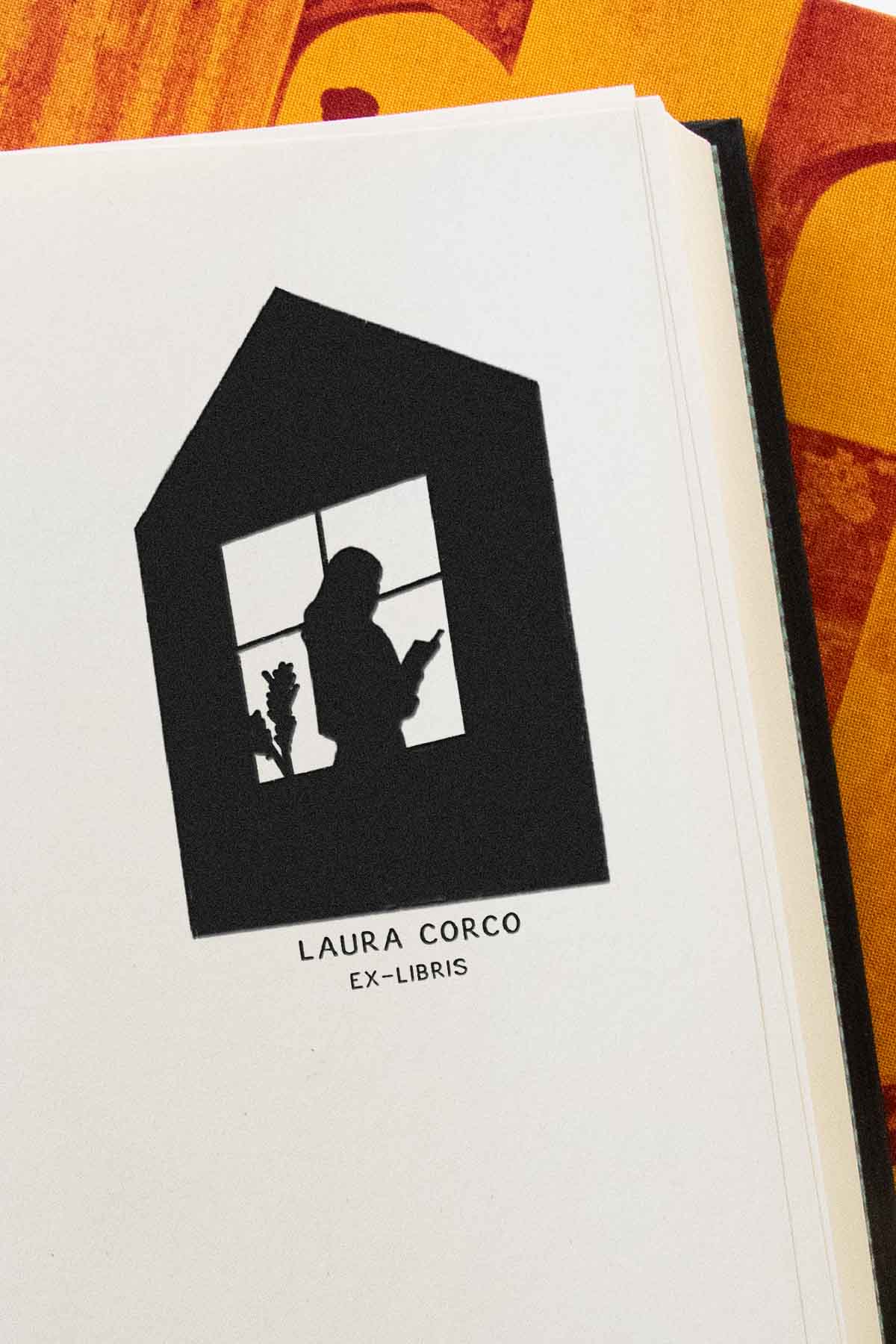 Portadilla de libro estampada con sello exlibris de una silueta de una persona leyendo un libro junto a una ventana