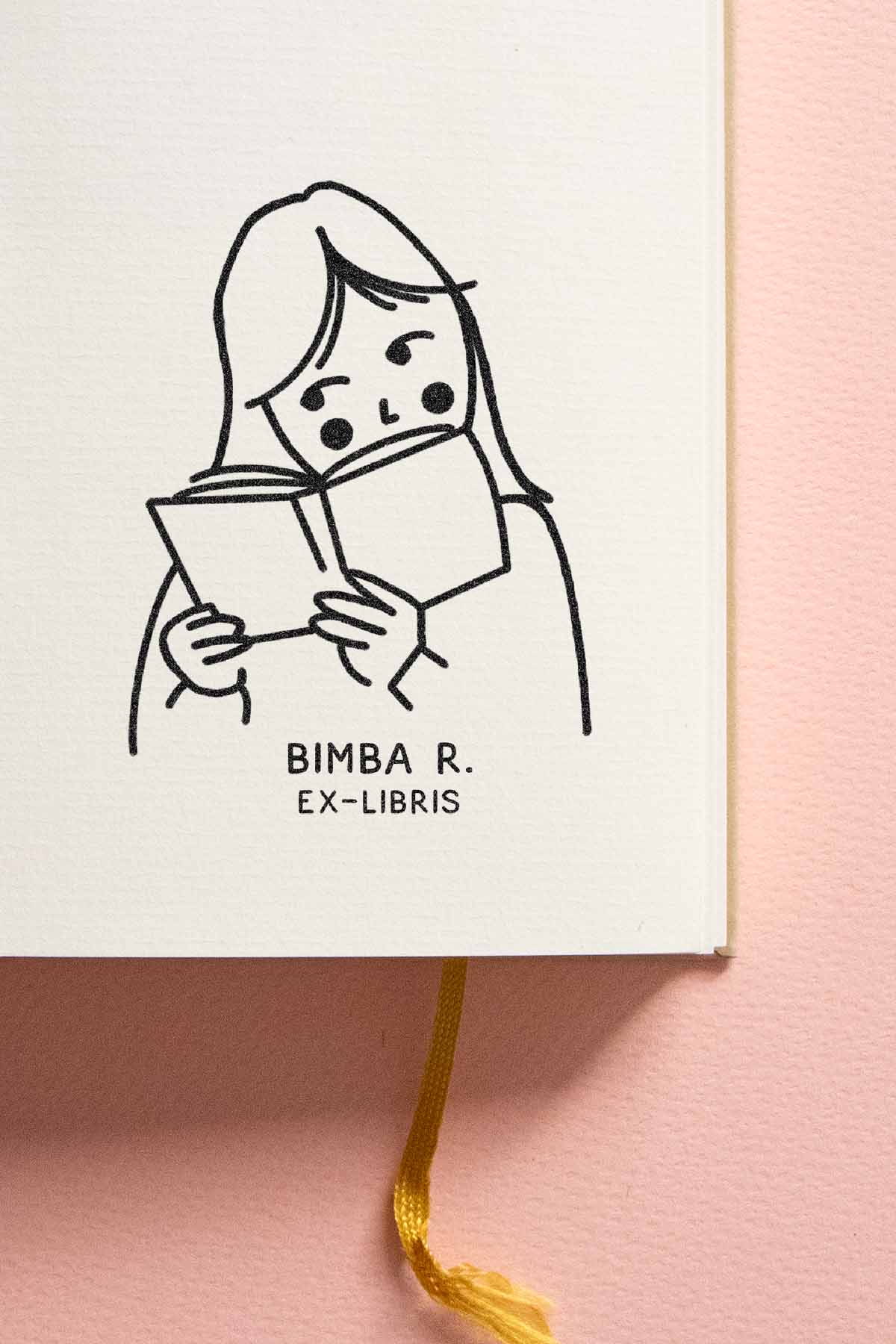 Portadilla de libro estampada con sello exlibris de una niña leyendo