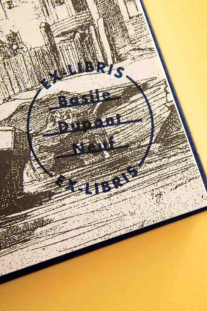 Página de guarda estampada con un sello exlibris de un círculo con mención exlibris y nombre del propietario